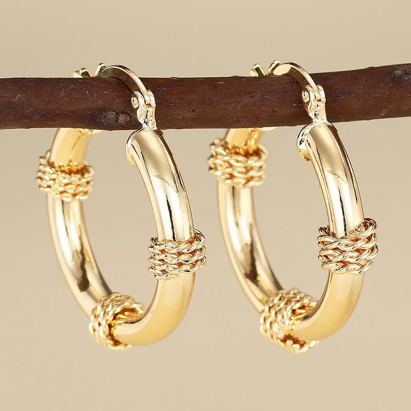 Geometric copper earrings with ring and line design in a gold colour.