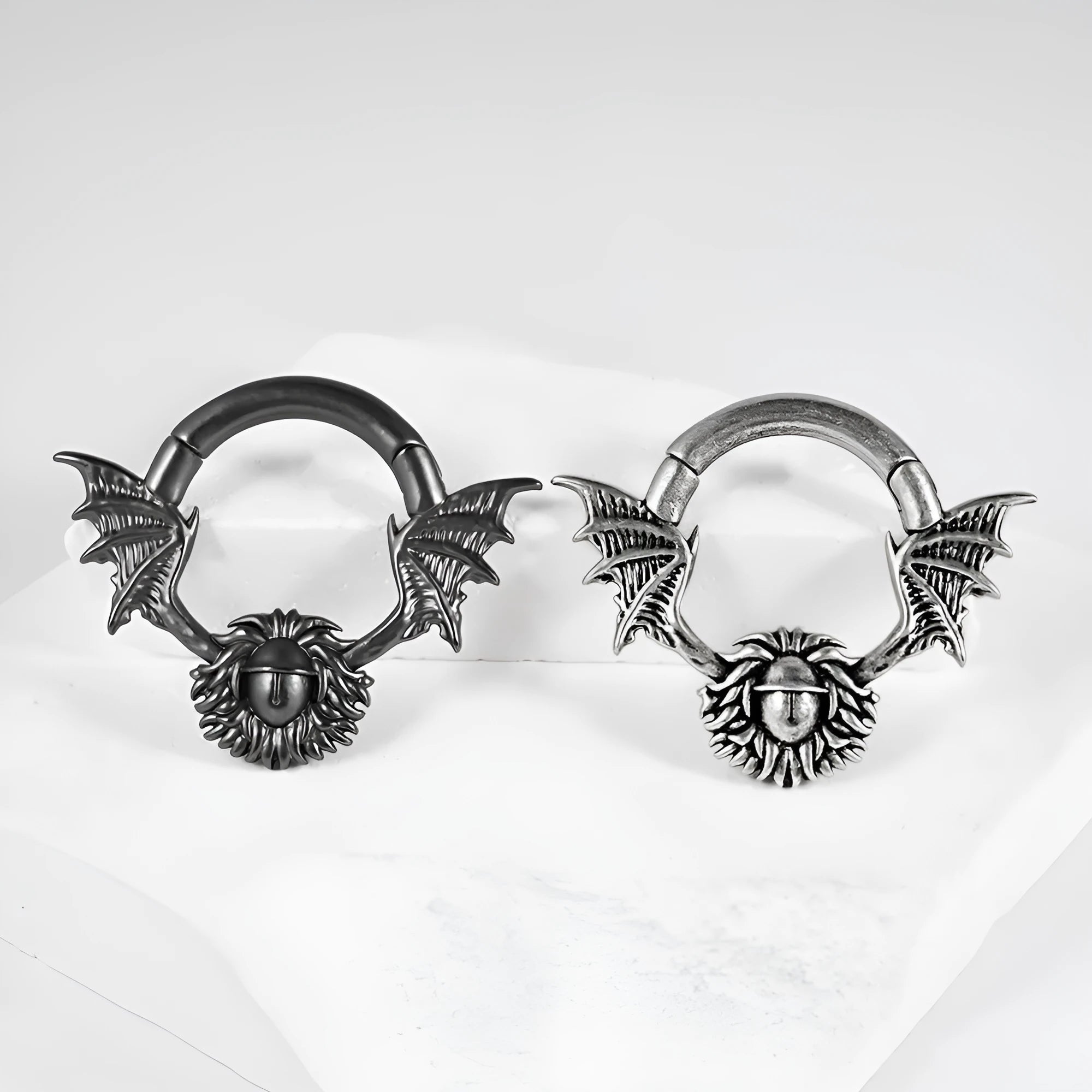 A pair of geometric sharp cone and round copper ear extenders with a magnetic closure in a silver finish.
