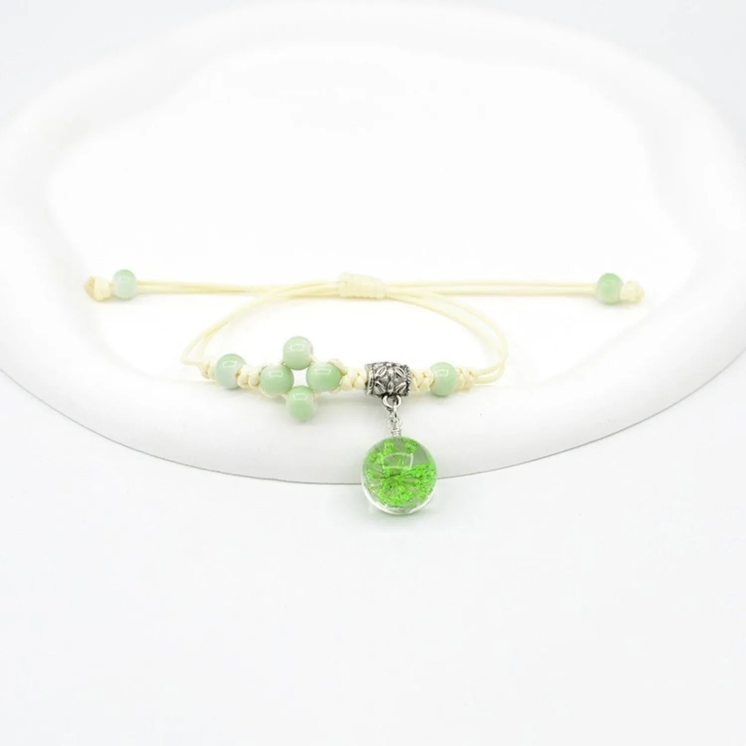Close-up of a hand-woven glass bracelet with large 1.4 cm beads containing real dried flowers in multiple colour options.