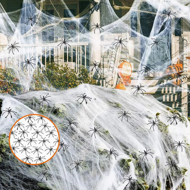 White cotton spider web Halloween decoration with multiple attached spiders draped over a surface.