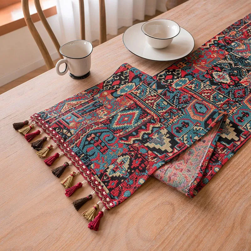 Dark blue Nordic Jacquard table runner with bouquet design and tassels laid on a wooden table.