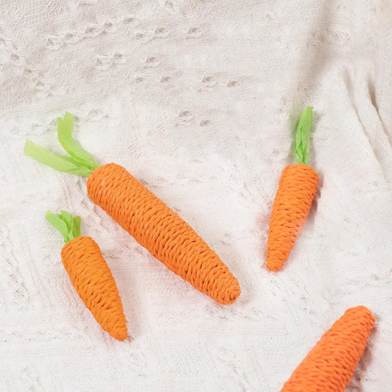 Assortment of cat toys including paper carrot bites, ringing stones, interactive sticks, and dental grinding sticks