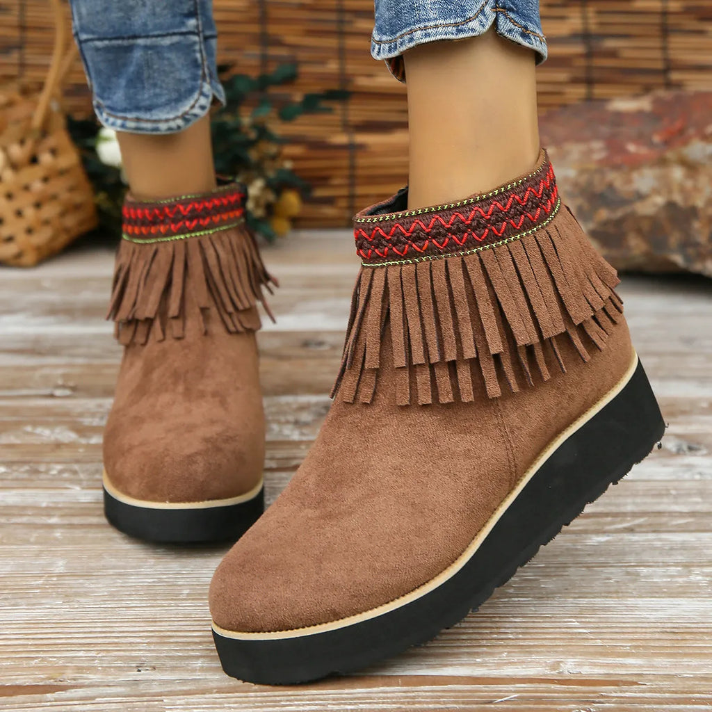 Women's suede ankle boot with wedge heel, side zipper, and tassel detail in dark brown.