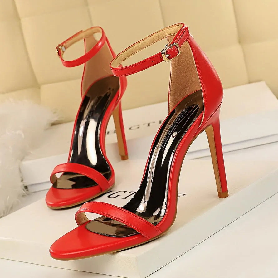 Women's open toe high heels with an ankle strap and buckle closure in a solid colour.