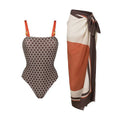Women's printed dot pattern one-piece swimsuit with matching wrap skirt on a hanger.