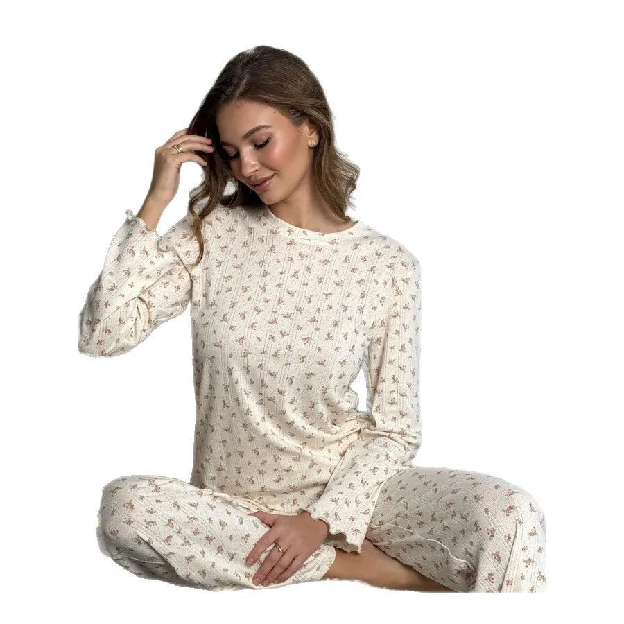 White women's floral print two-piece suit with bell sleeve top and wide-leg trousers on a hanger.