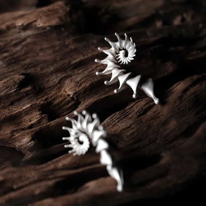 Exaggerated three-dimensional conch shell stud earrings with a matte finish in an irregular abstract design.