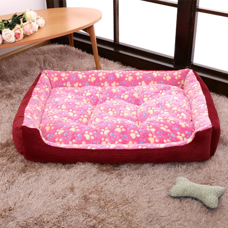 Beige plush sofa-style pet bed for small dogs with a raised bolster edge, shown in a home setting.
