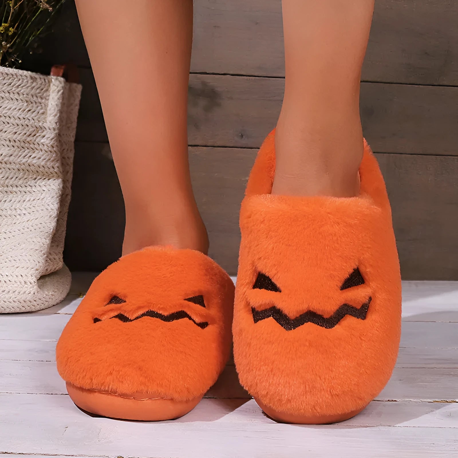 Orange pumpkin-themed plush slippers with a non-slip sole for indoor home wear.