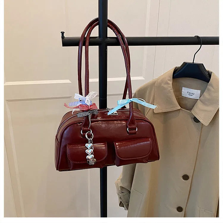Retro pillow-shaped leather women's handbag with one shoulder underarm design in black with ribbon pendant