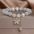 Women's white cat's eye stone bracelet with flower tassel and safety buckle pendant.