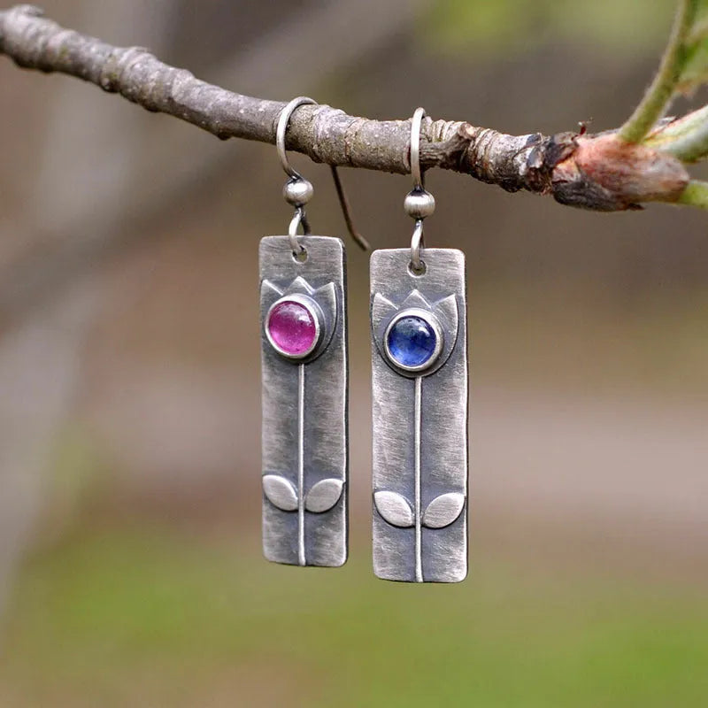 A pair of red sapphire earrings with an antique finish and geometric design.