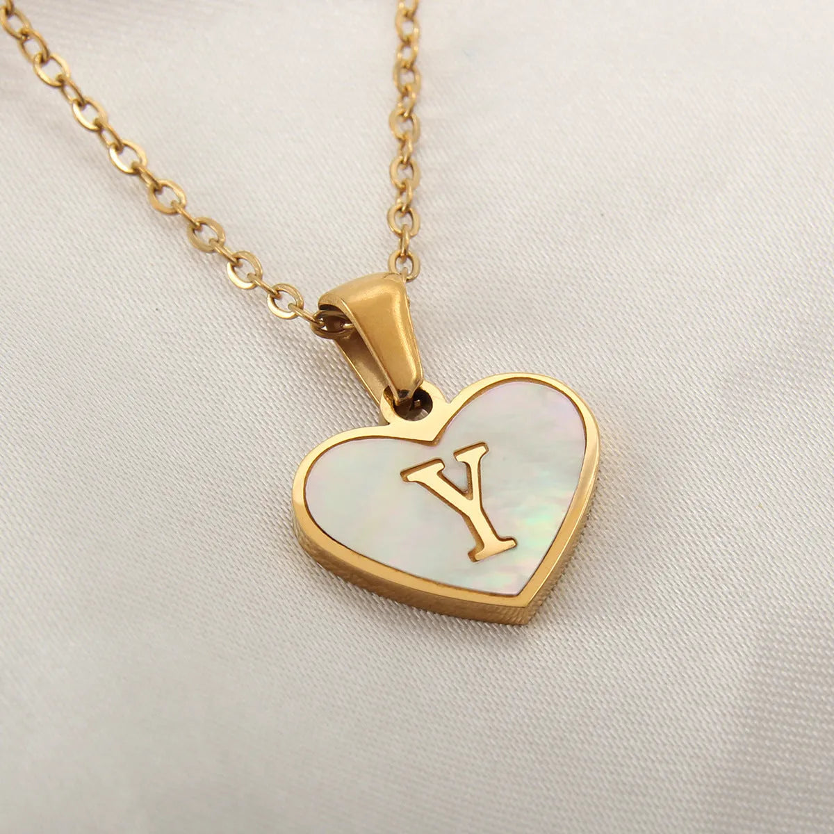 Gold plated heart-shaped necklace with white shell pendant on adjustable stainless steel chain