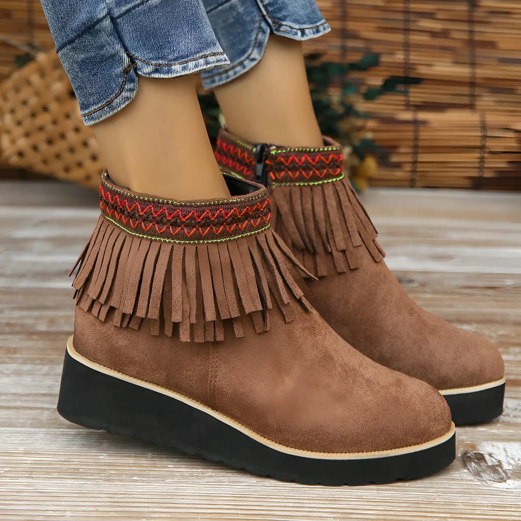 Women's suede ankle boot with wedge heel, side zipper, and tassel detail in dark brown.