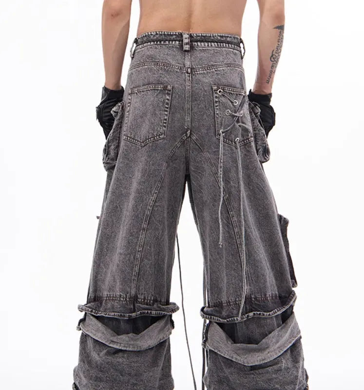Grey distressed denim overalls with rope stitching detail on a hanger.
