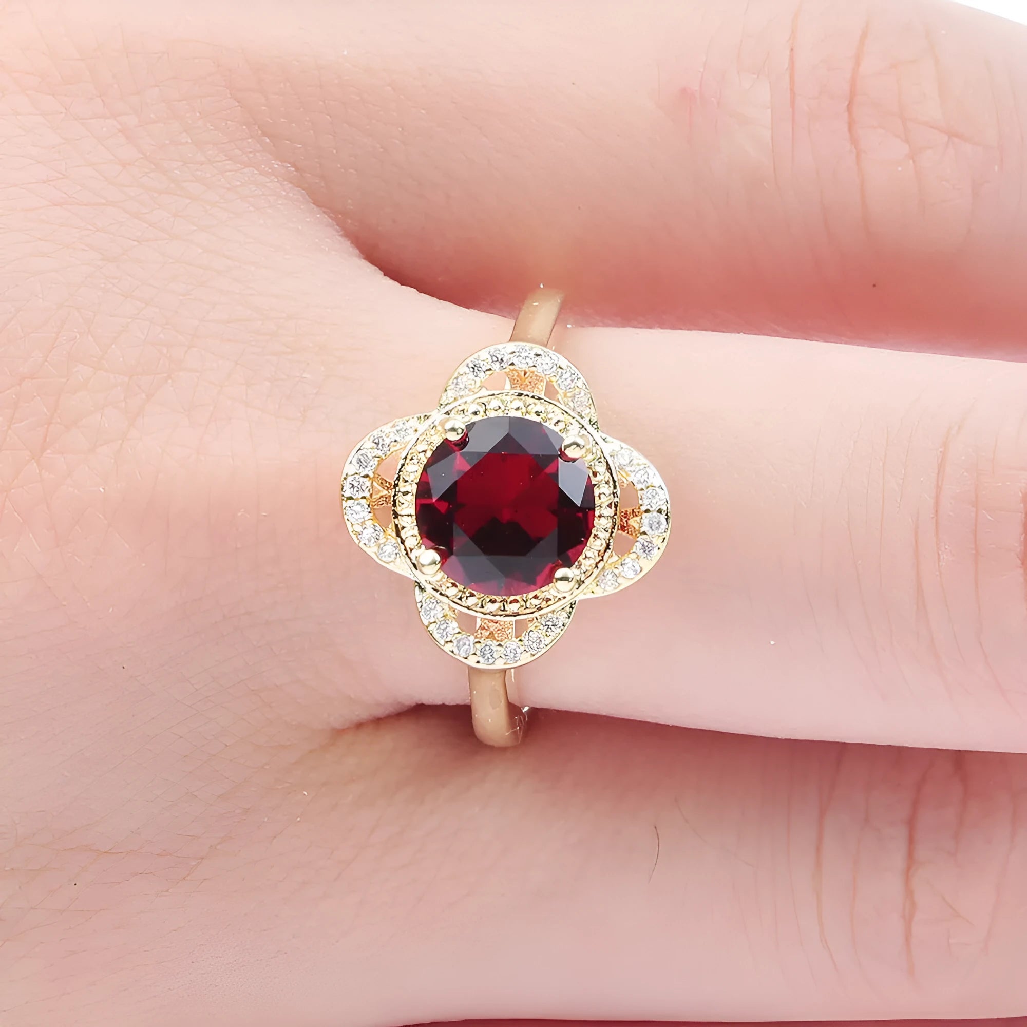 Copper fruit-shaped ring with electroplated zircon detailing on a hand.