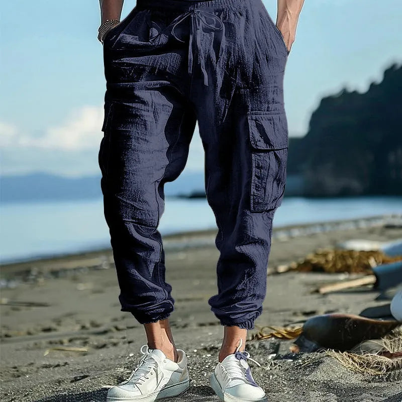 Men's loose-fit linen trousers with ankle-tied cuffs and multiple pockets.