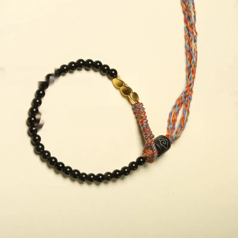 Hand-woven obsidian carrying strap bracelet showing textured weave and adjustable length