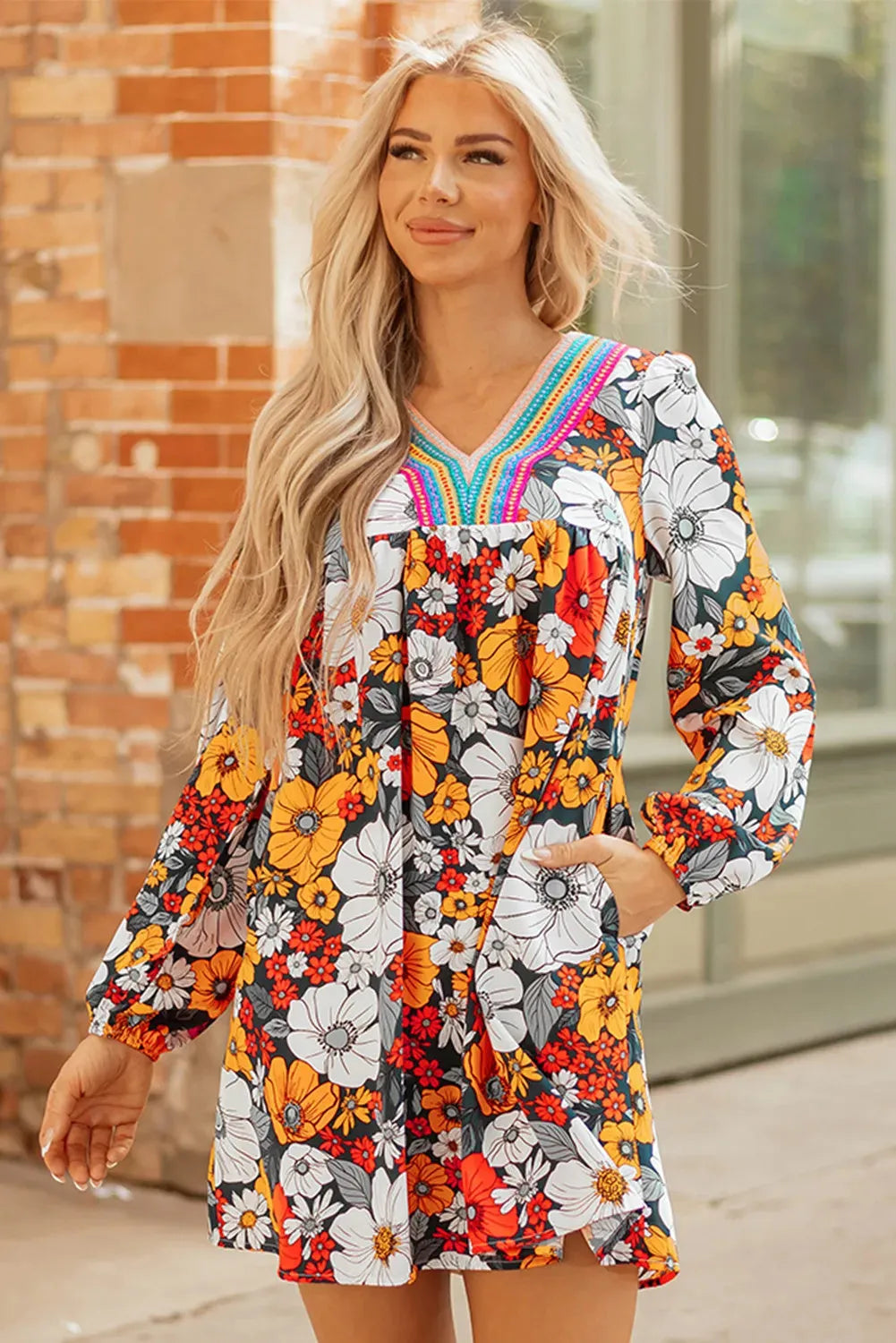 Orange floral print women's mini dress with striped lace trim, V-neck, and long sleeves.