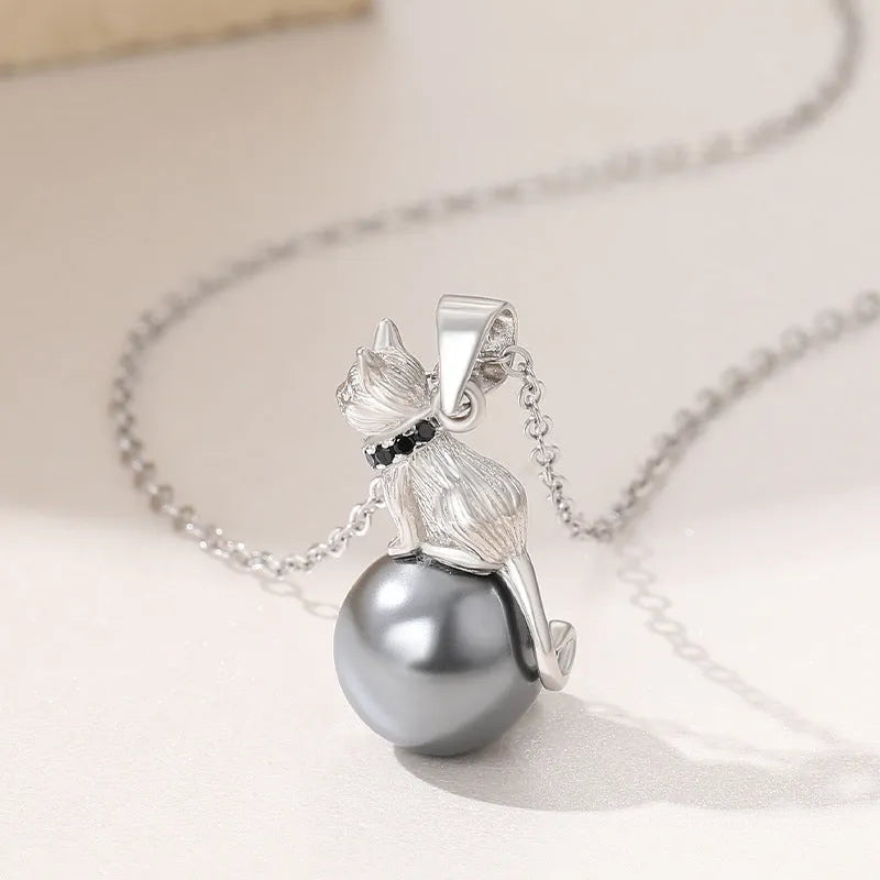 Close-up of a sterling silver cat silhouette pendant on a clavicle-length chain.