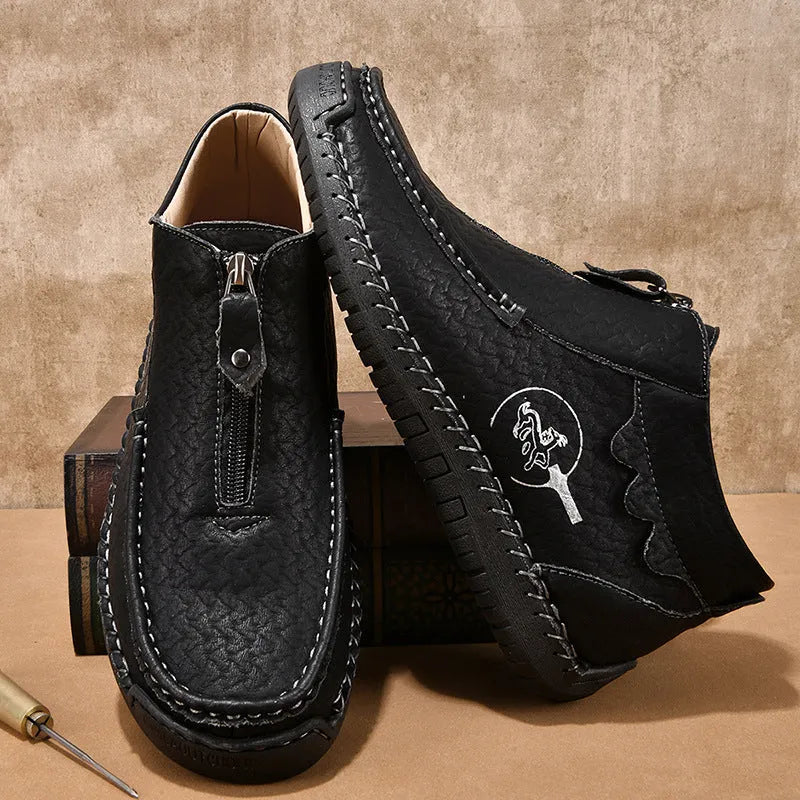 Men's black slip-on loafers with round toe and sewing thread detail on a rubber sole.