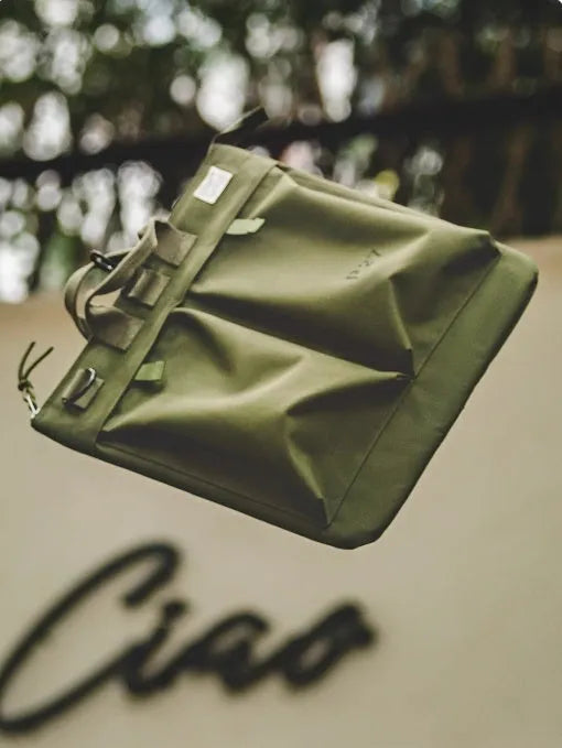 Canvas crossbody messenger bag in military green with shoulder strap showing vertical square shape and zipper closure