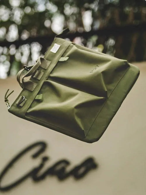 Canvas crossbody messenger bag in military green with shoulder strap showing vertical square shape and zipper closure