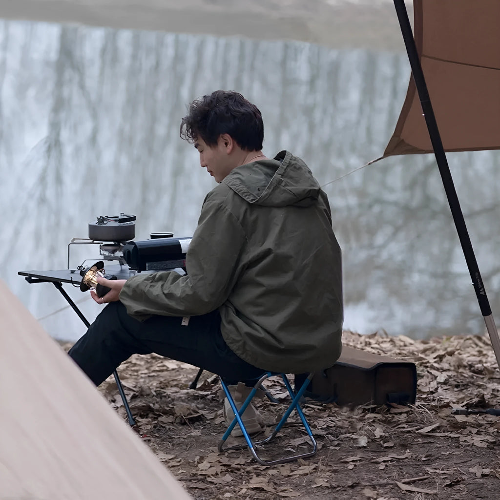 Black folding stool with an aluminium alloy frame, shown both folded and open for outdoor use.
