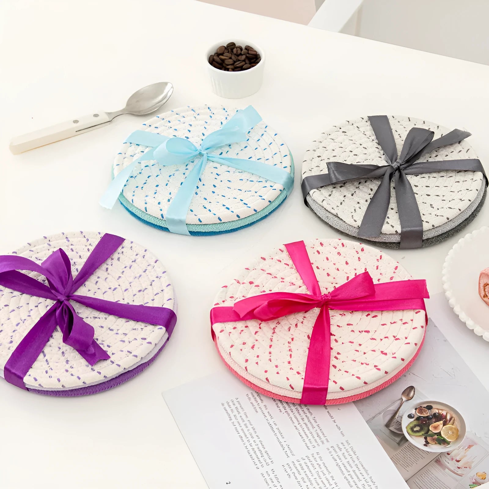 Set of three round grey cotton cord coasters on a wooden table, each 18cm in diameter.