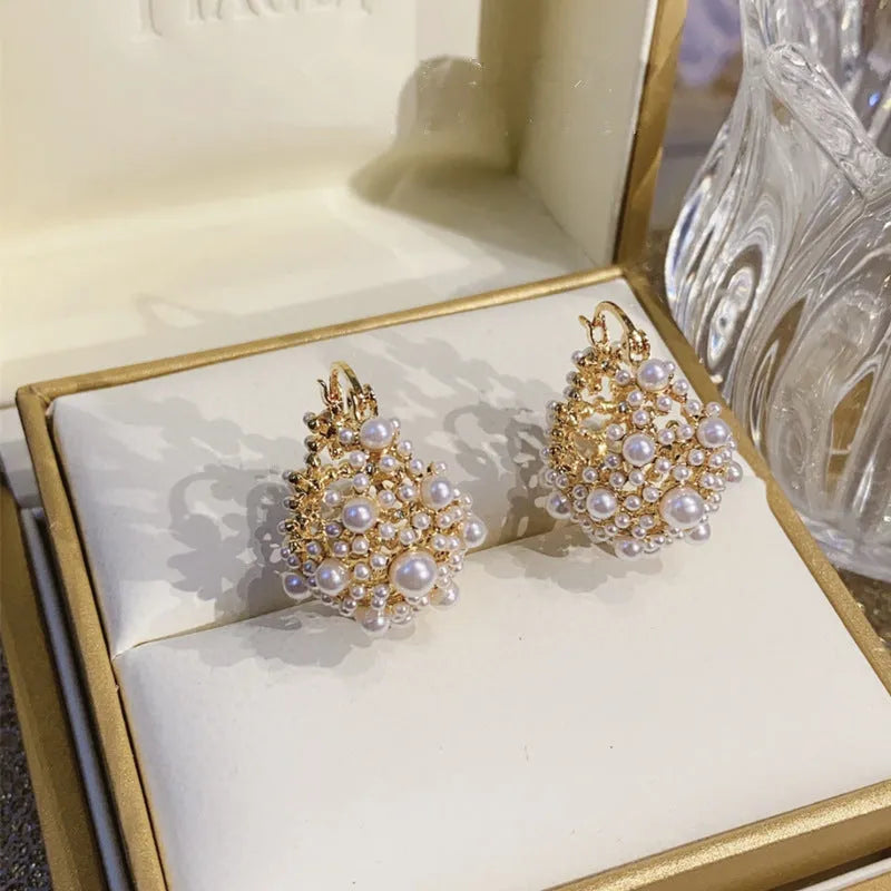 Gold copper flower basket earrings with small rice-shaped bead decoration and pearl inlay.