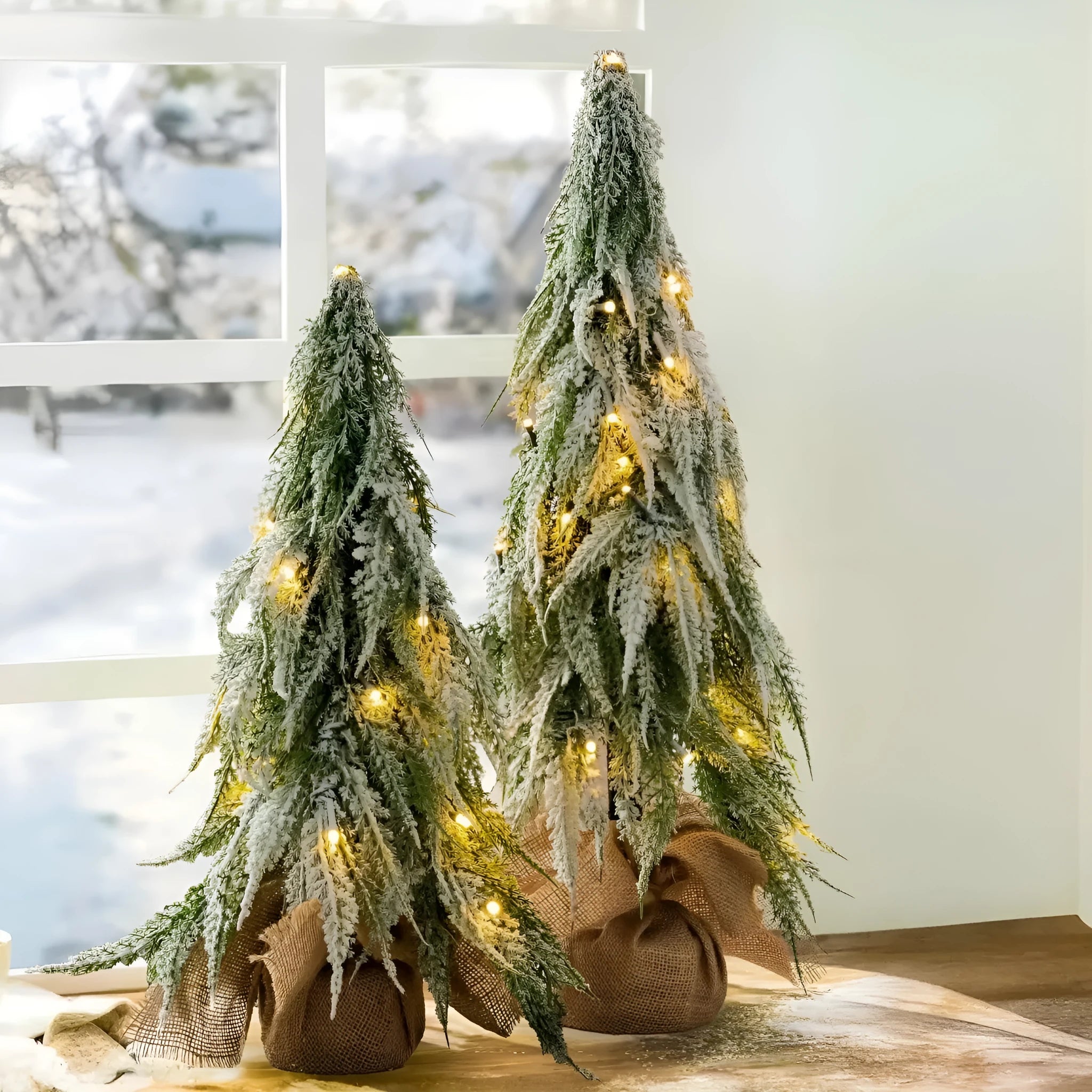 Small 24-inch white artificial Christmas tree with LED lights and snow spray on plastic branches
