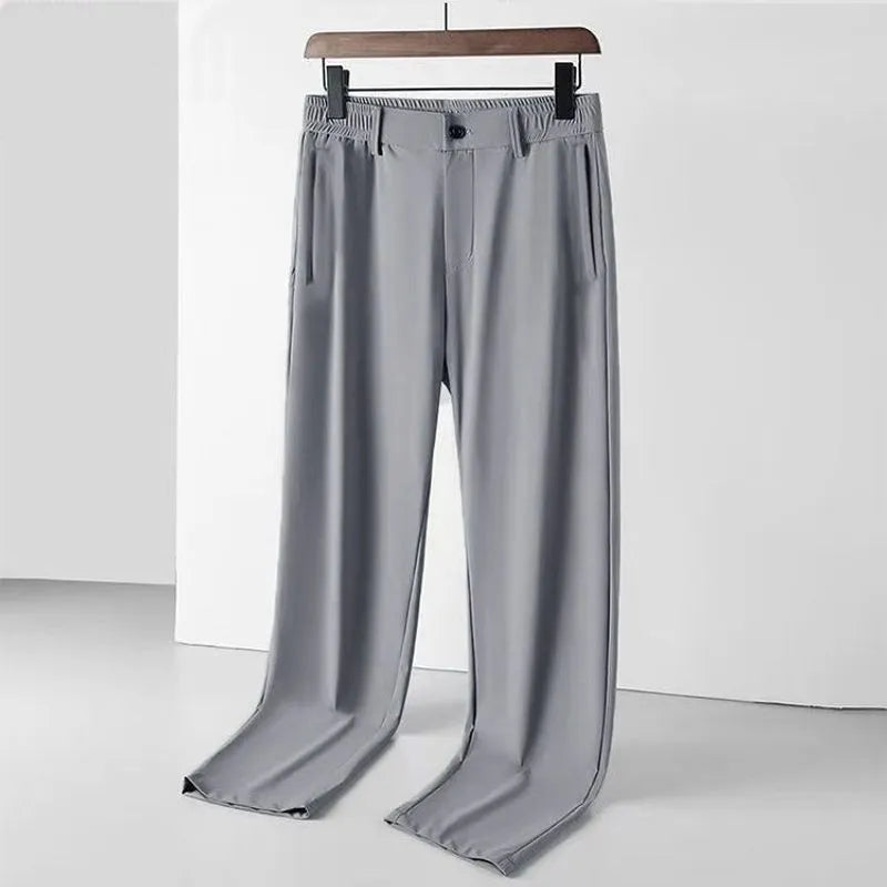 Man wearing black Ice Silk straight-leg loose trousers with an elasticated waist for leisure.