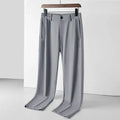 Man wearing black Ice Silk straight-leg loose trousers with an elasticated waist for leisure.