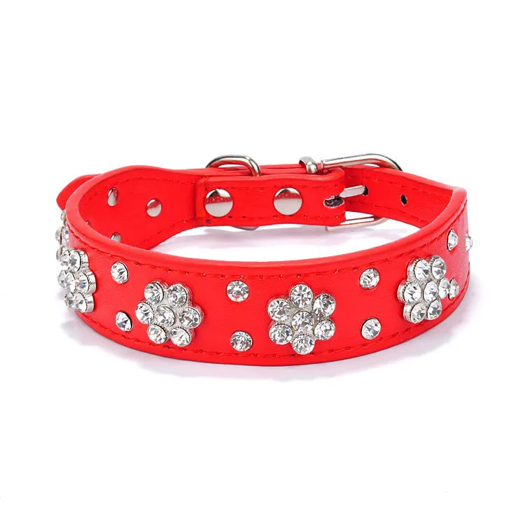 Close-up of a black PU leather dog collar with sparkling rhinestone flowers and a metal D-ring.