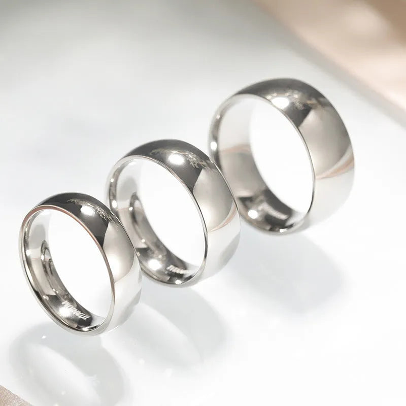Silver titanium steel unisex ring shown in different band widths on a hand.