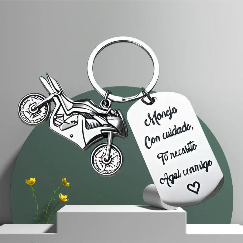 Stainless steel motorcycle keychain with inspirational design on a flannel bag.