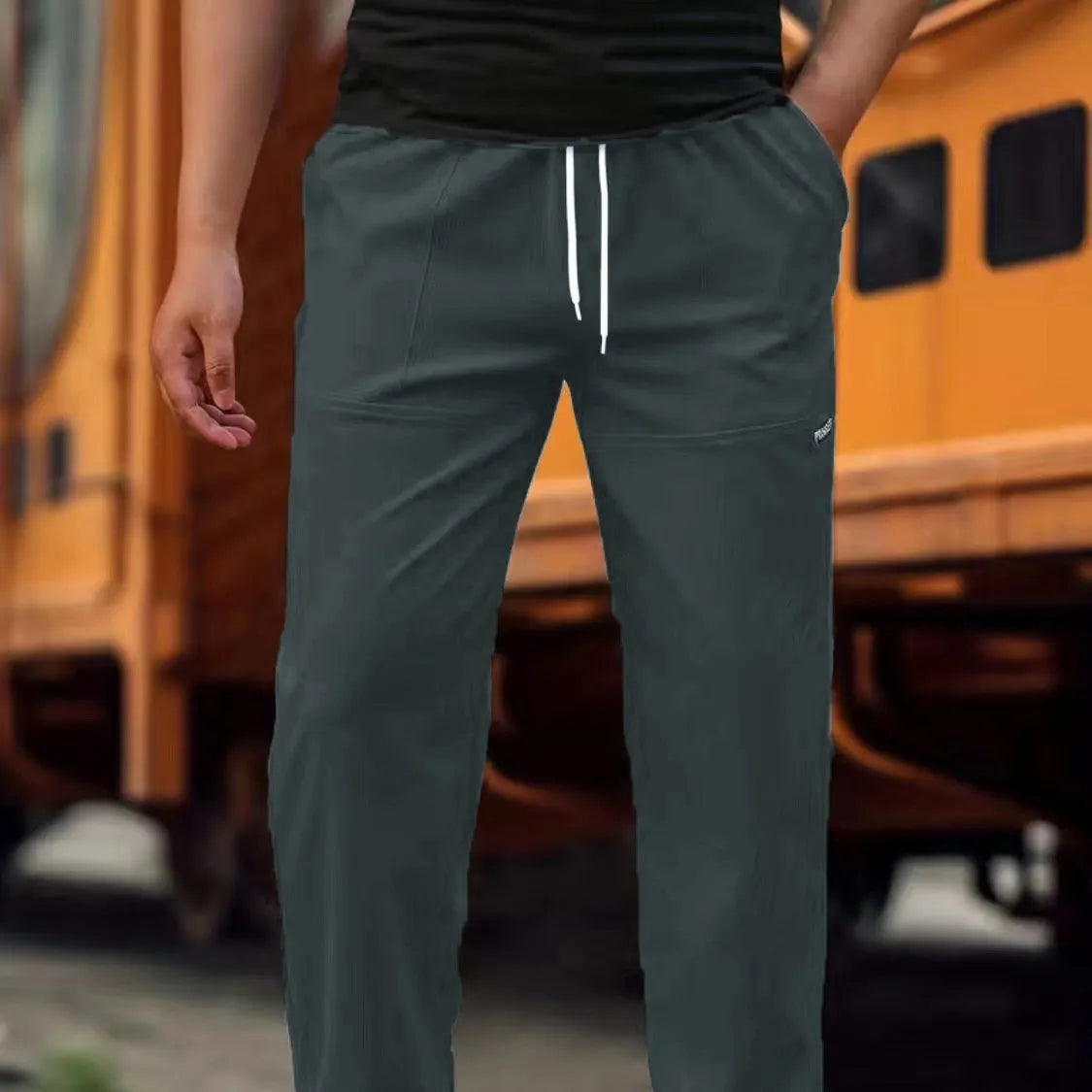 Men's straight-leg lightweight polyester trousers in light grey colour, laid flat showing front design