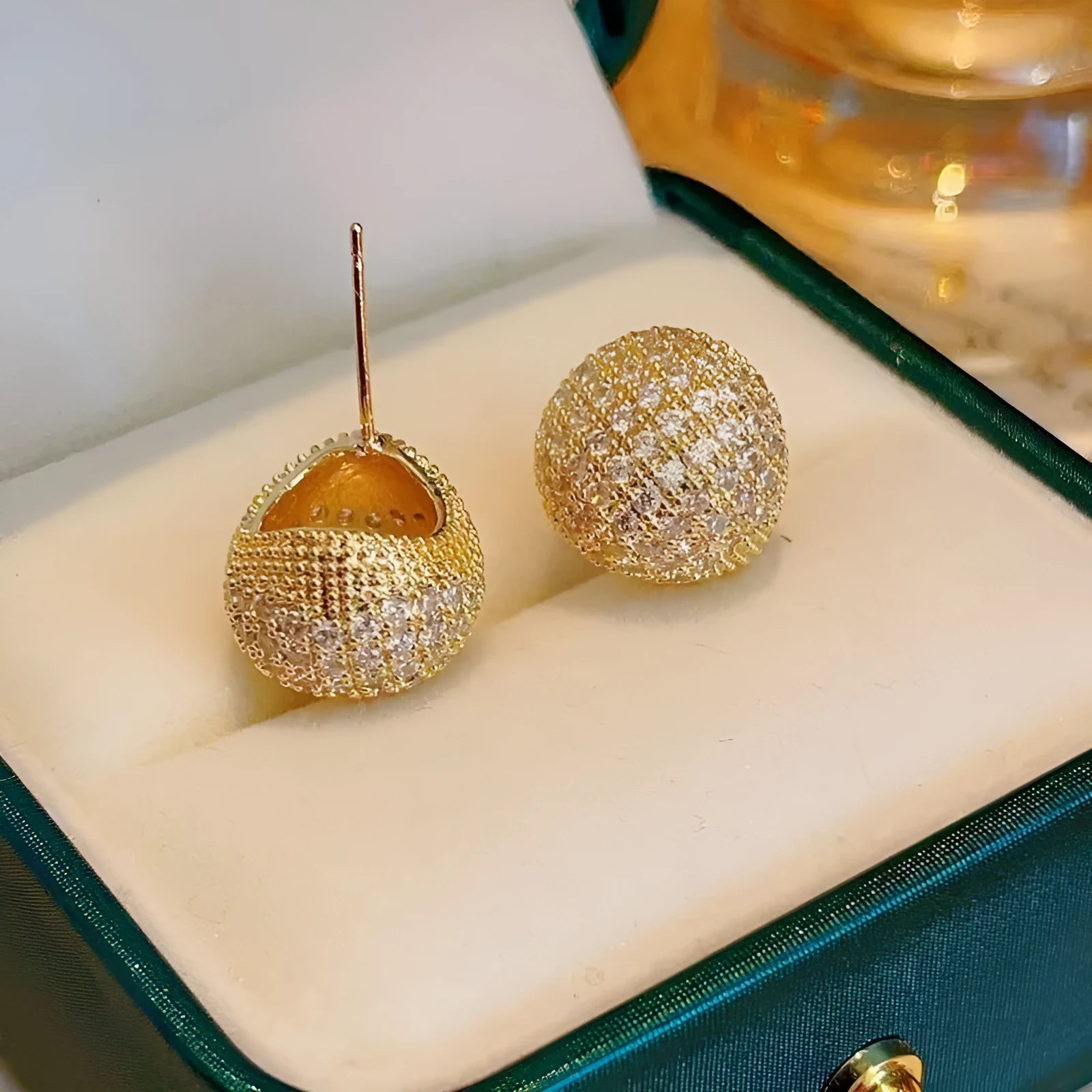 Geometric drop-shaped clip earrings with sphere elements and diamond flashing in gold or white colour