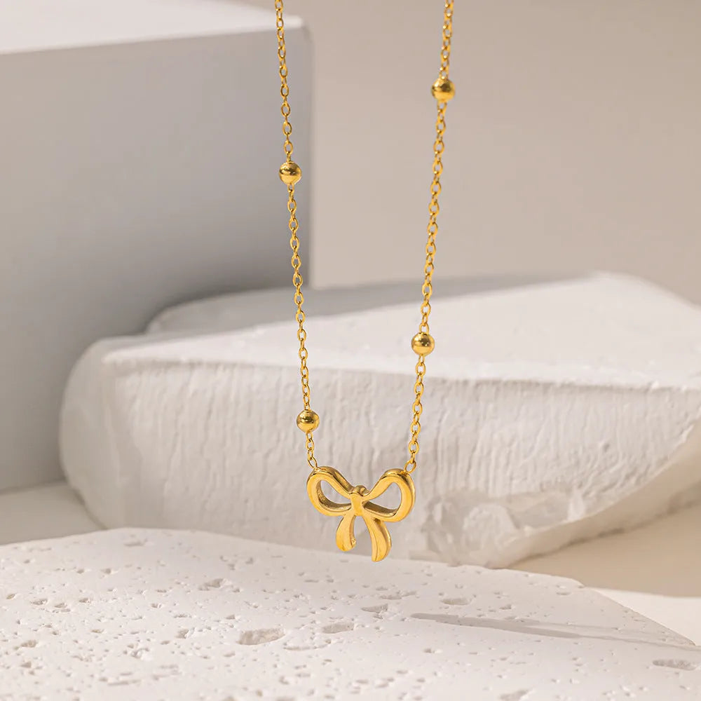 Gold titanium steel bow necklace on cross chain, adjustable 41-50 cm, for women's fashion
