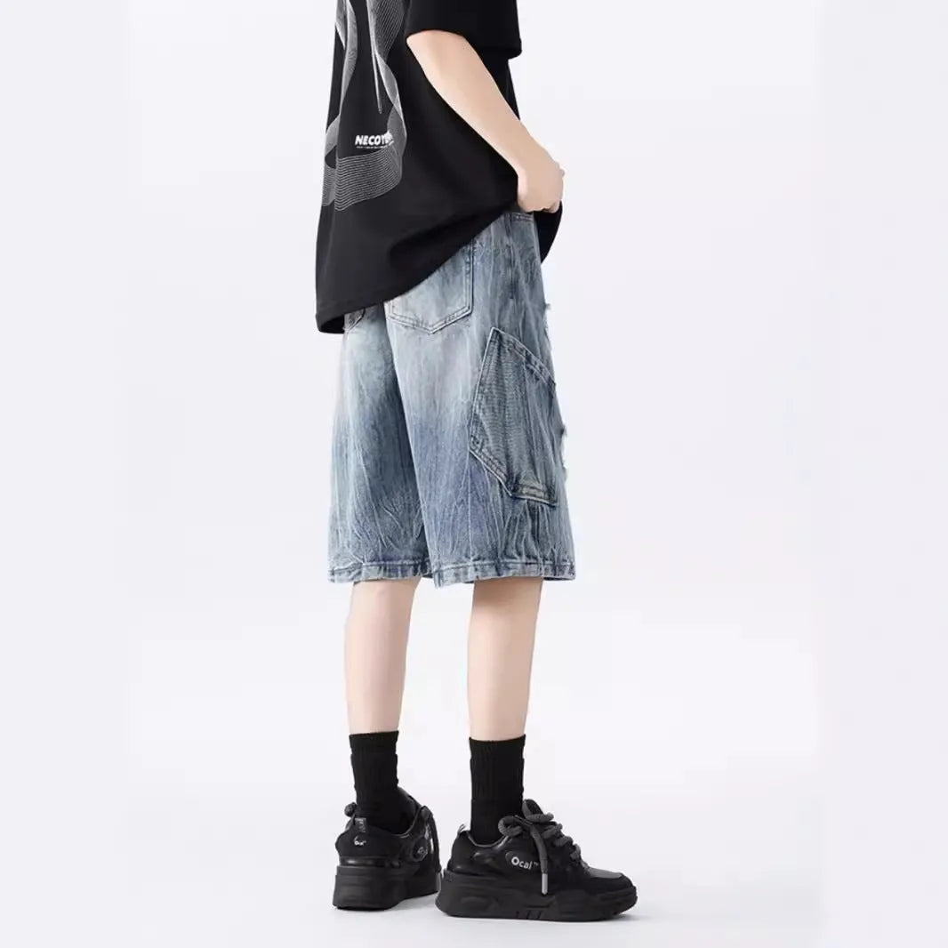 Loose washed blue denim shorts with a ripped knee detail on a mannequin, showing the retro fit.