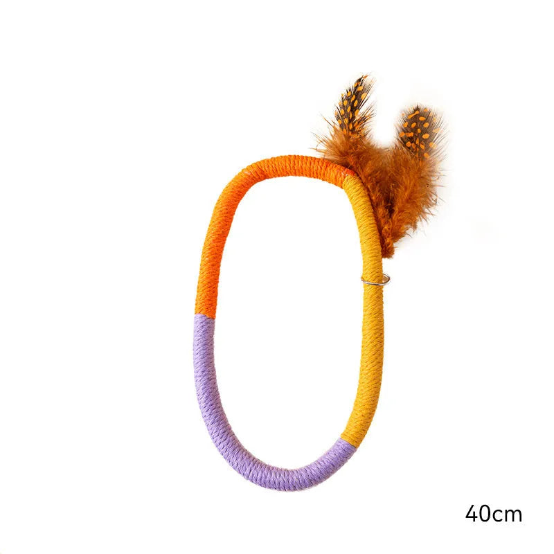 Green circular cotton rope cat toy with white feathers attached for interactive feline play