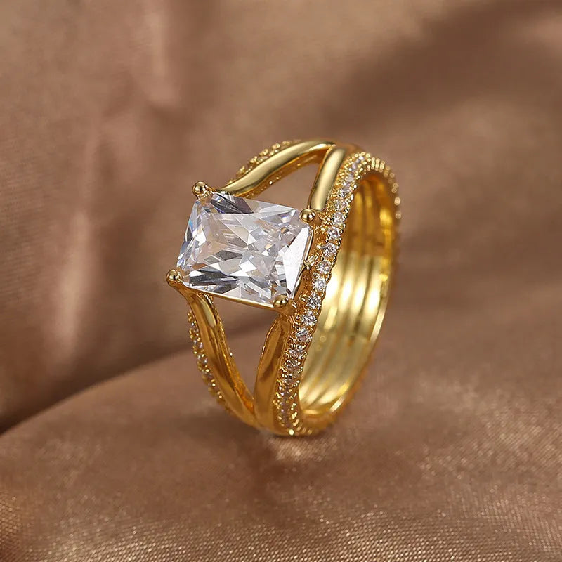 Geometric gold-coloured women's ring with square zircon stone on copper band
