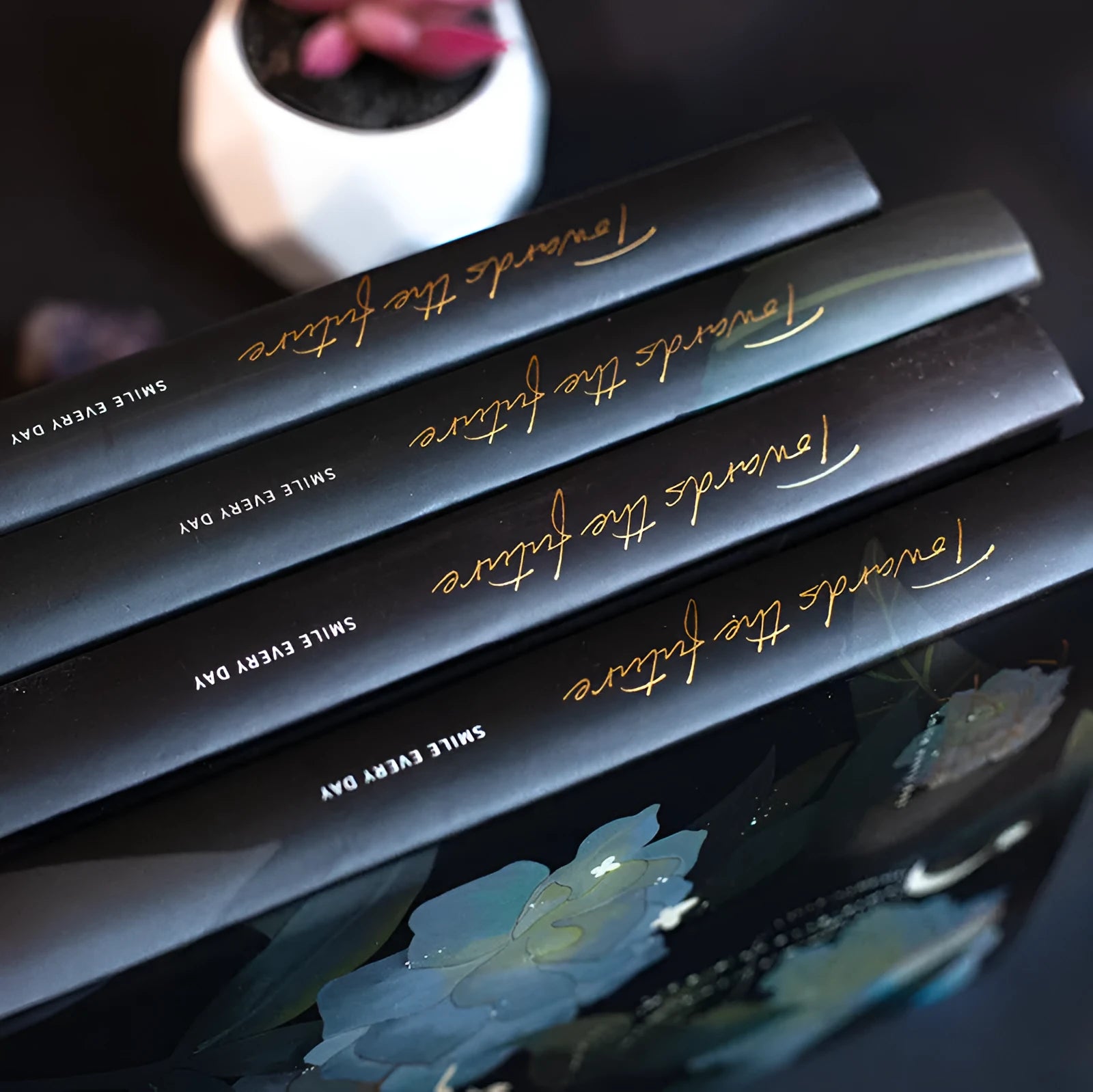 A5 notebook with a luminous cover in one of four colours, open to show pages with colour illustrations