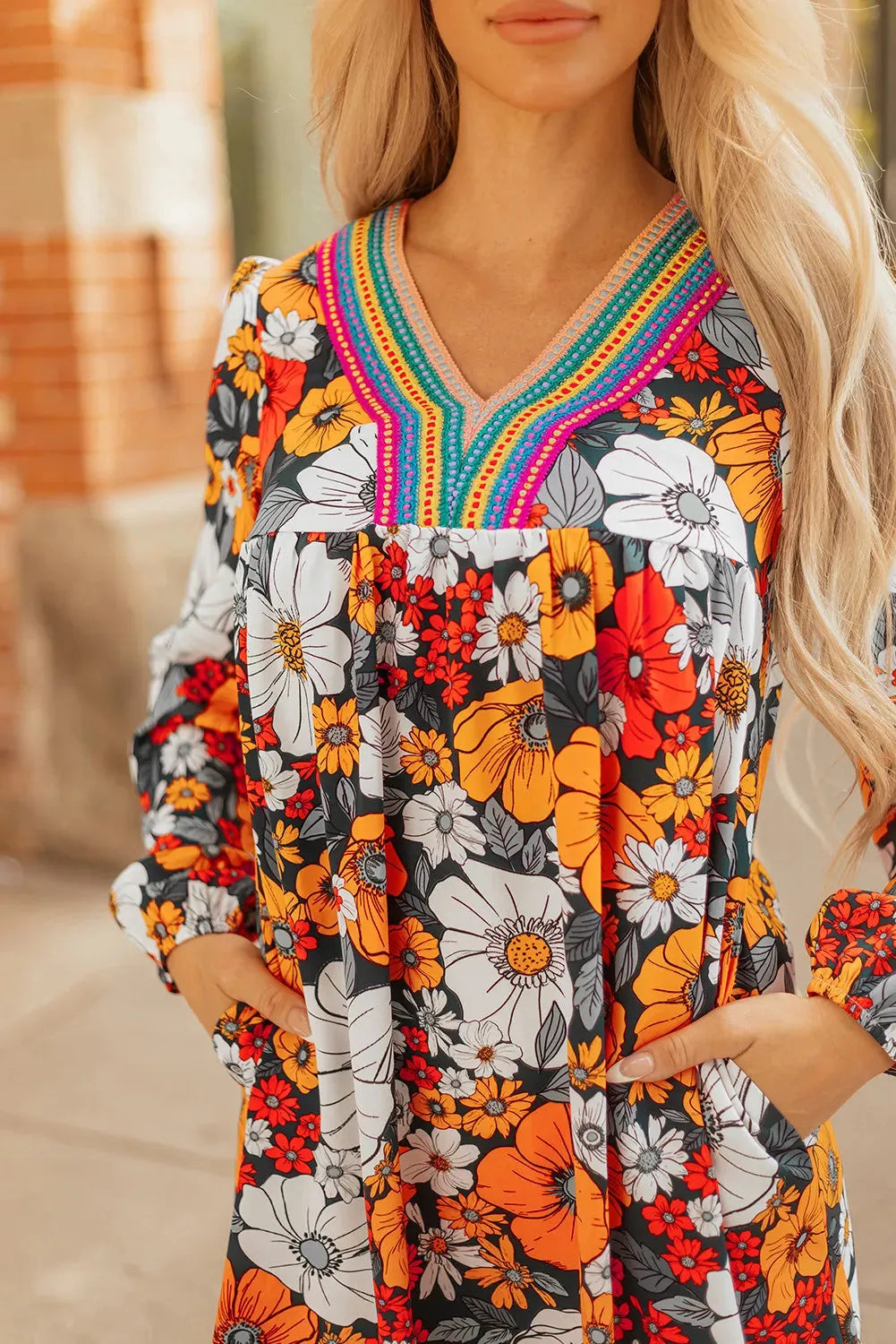 Orange floral print women's mini dress with striped lace trim, V-neck, and long sleeves.