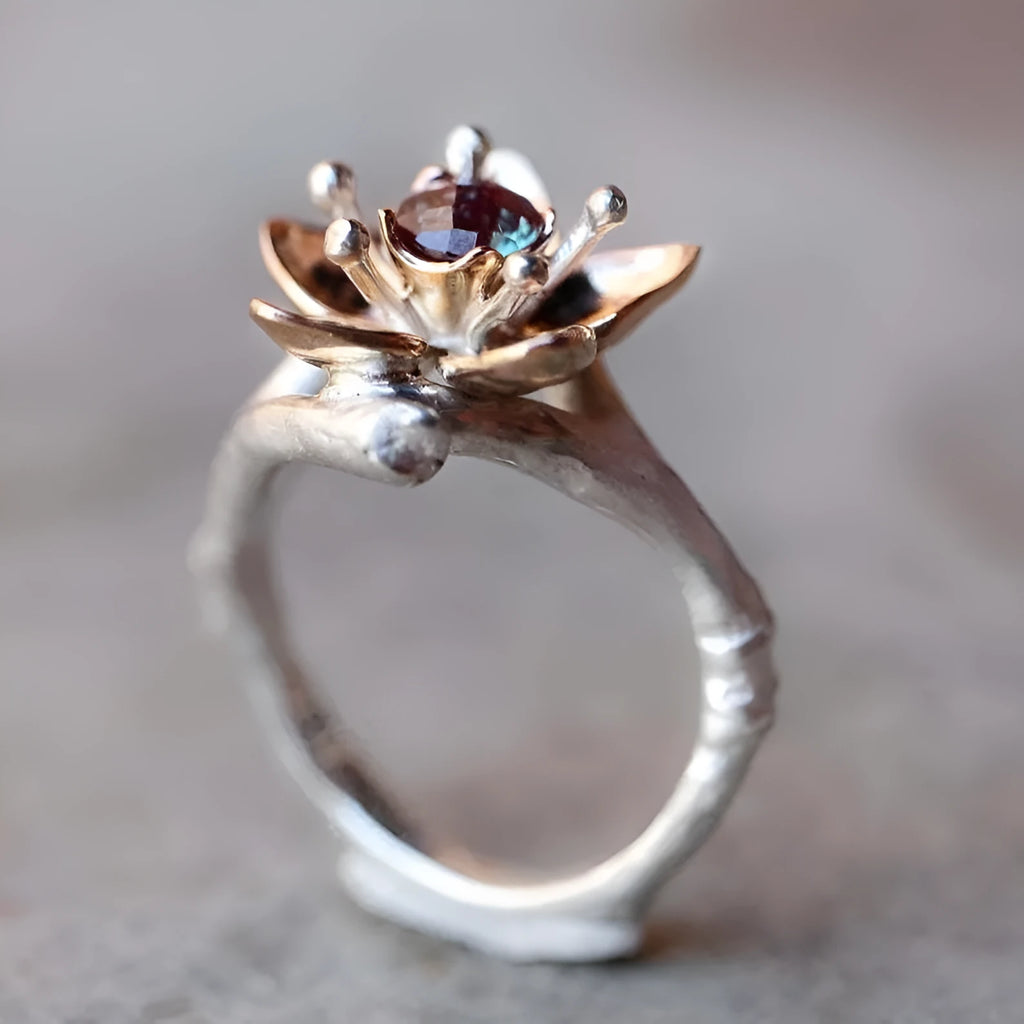 Silver-tone alloy women's ring with geometric shape and two-tone floral design on a white background.