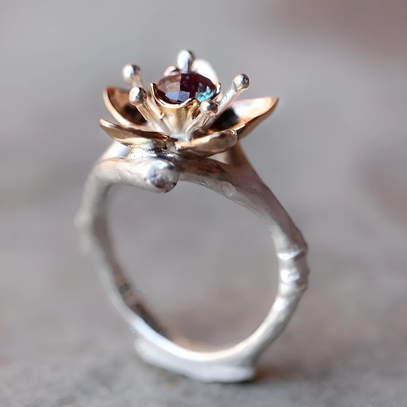 Silver-tone alloy women's ring with geometric shape and two-tone floral design on a white background.