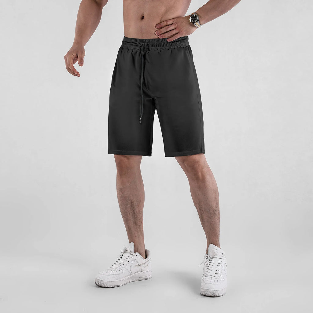 Man wearing black quick-dry mesh fitness shorts with a loose, casual fit and elasticated waistband.