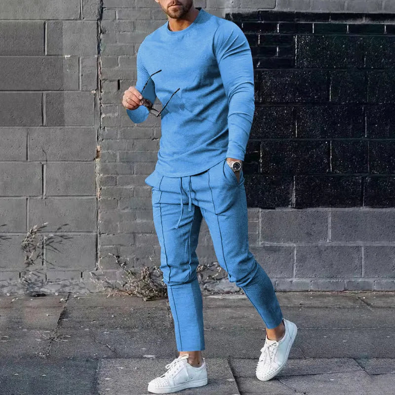 Men's light grey polyester two-piece suit with long sleeve round neck T-shirt and matching trousers laid flat.