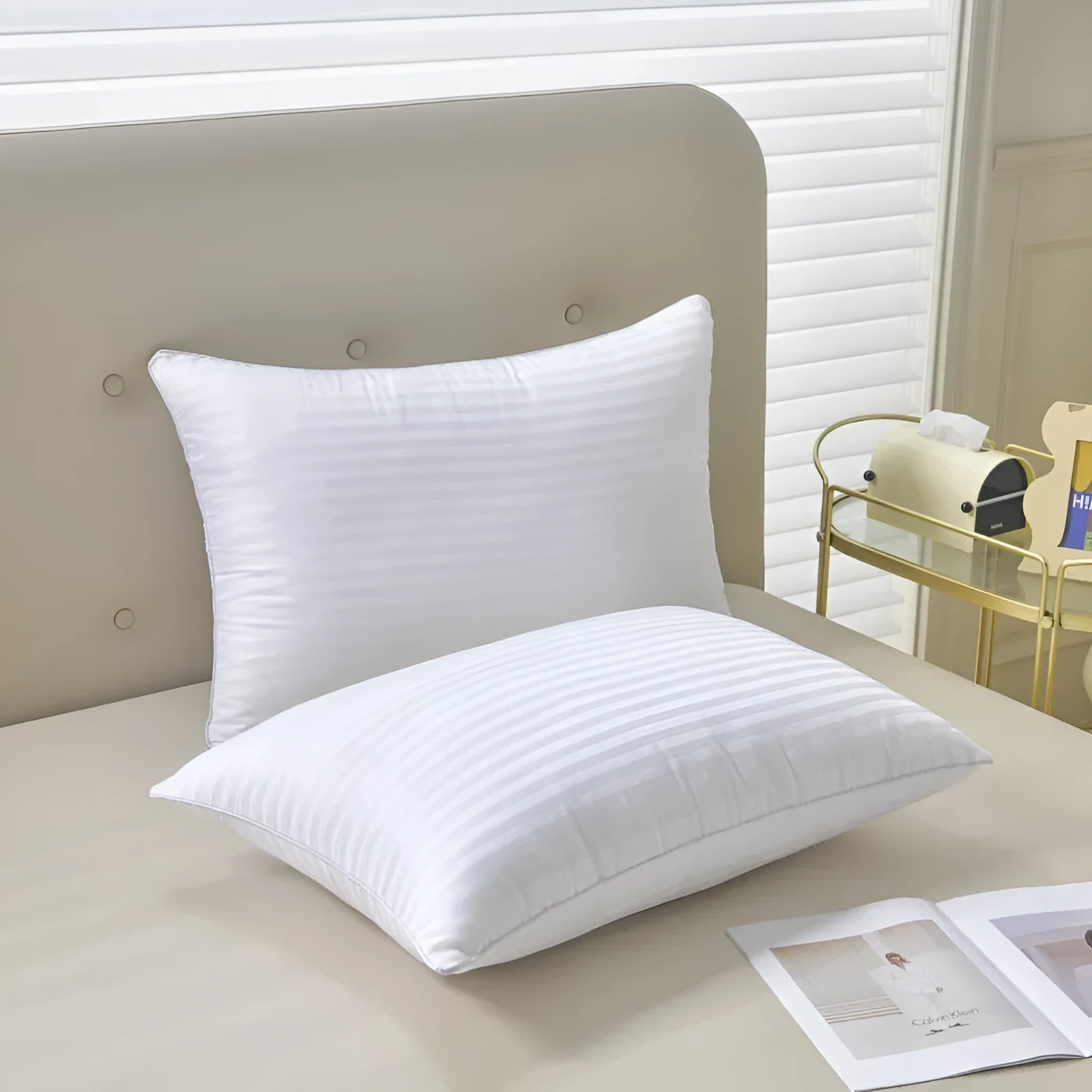 White hotel cotton satin stripe pillow with feather and cotton filling on a bed.
