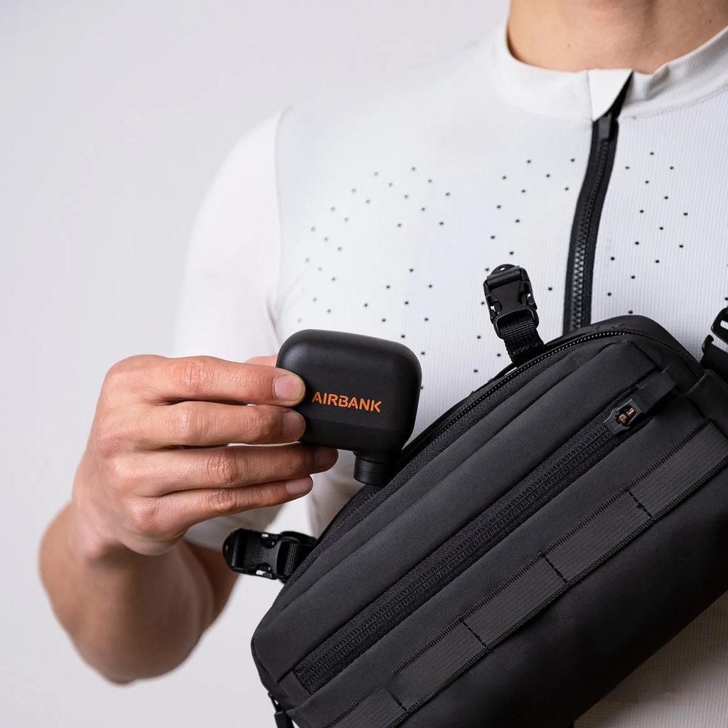 Black AS100 electric bike pump with USB cable and waterproof bag on a white background.